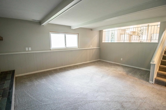 empty room with beamed ceiling and carpet