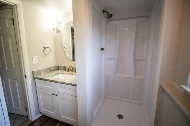 bathroom featuring hardwood / wood-style floors, vanity, and walk in shower