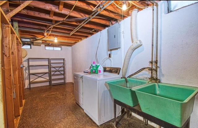 clothes washing area with separate washer and dryer, electric panel, and sink