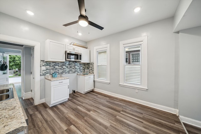 kitchen with tasteful backsplash, ceiling fan, dark wood-type flooring, sink, and white cabinets