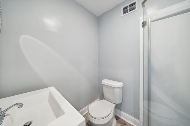 bathroom with walk in shower, sink, wood-type flooring, and toilet