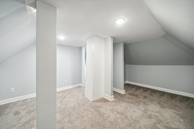 additional living space featuring lofted ceiling and light carpet