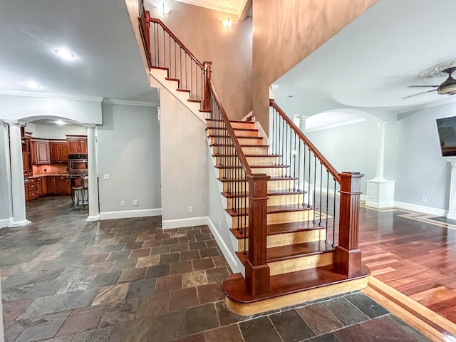 stairs featuring wood-type flooring, decorative columns, and ornamental molding