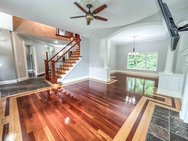 interior space with ceiling fan with notable chandelier, dark hardwood / wood-style flooring, ornate columns, and crown molding