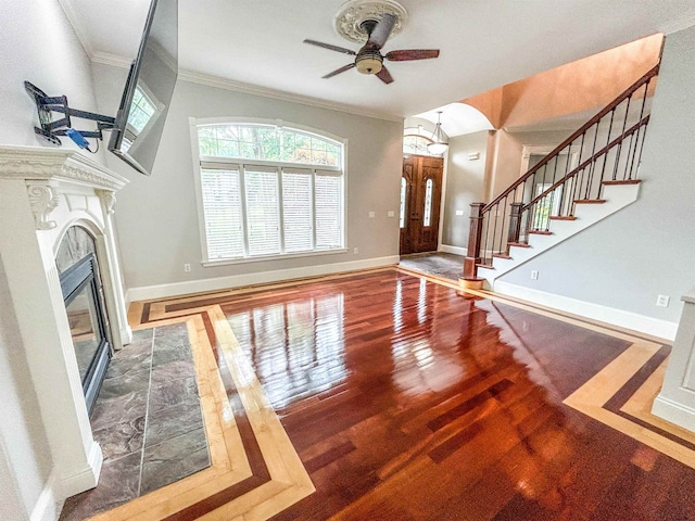 living room with a tile fireplace, crown molding, hardwood / wood-style floors, and ceiling fan