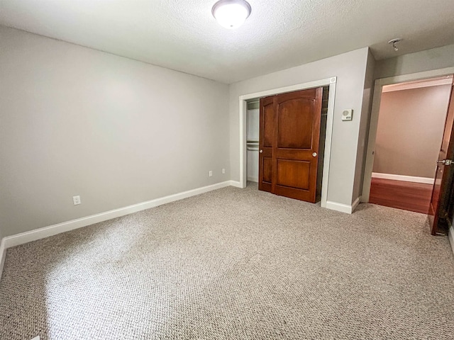 unfurnished bedroom featuring carpet, a textured ceiling, and a closet