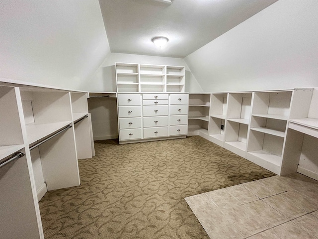 spacious closet featuring light colored carpet and lofted ceiling