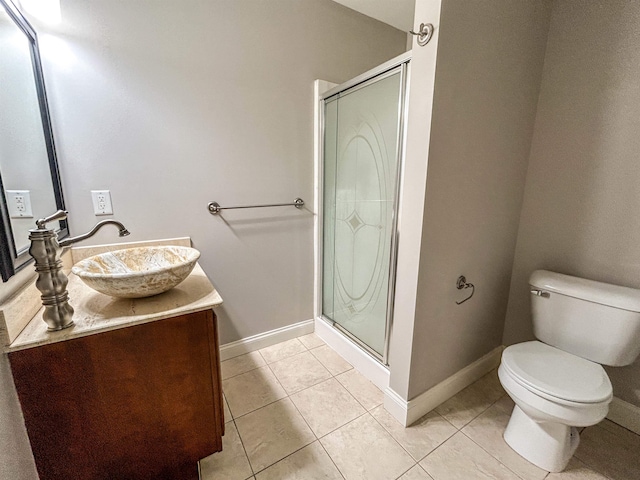 bathroom with tile patterned floors, vanity, toilet, and a shower with shower door