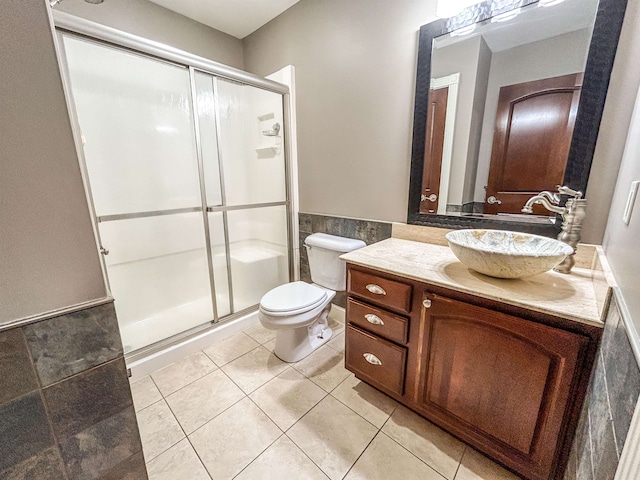 bathroom with tile patterned floors, walk in shower, vanity, and toilet