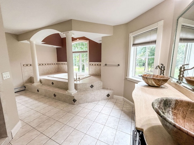 bathroom featuring vanity, a baseboard heating unit, tile patterned flooring, tiled bath, and decorative columns