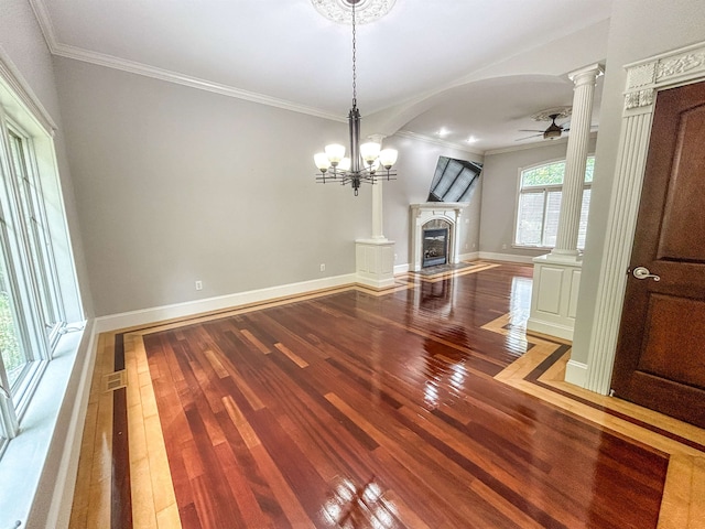 unfurnished living room featuring ornate columns, crown molding, wood-type flooring, and ceiling fan with notable chandelier