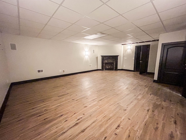 basement featuring wood-type flooring and a paneled ceiling