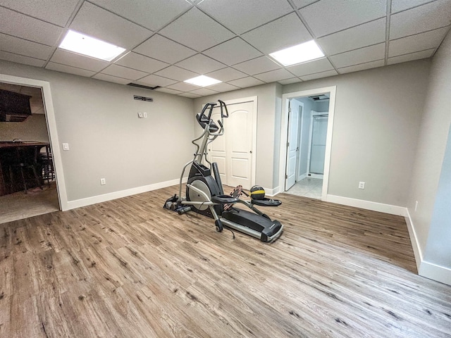 exercise area with a drop ceiling and light wood-type flooring