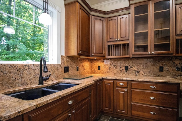 kitchen featuring sink, hanging light fixtures, tasteful backsplash, light stone counters, and crown molding