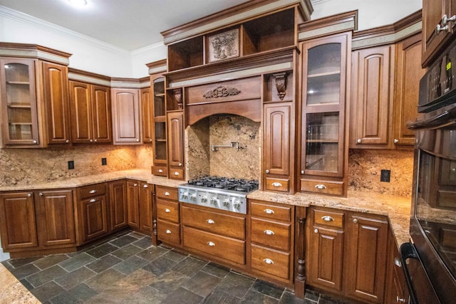 kitchen featuring stainless steel gas stovetop, decorative backsplash, light stone counters, and ornamental molding