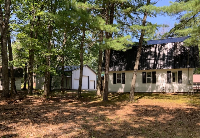 back of property with a garage and an outbuilding