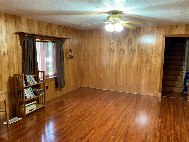 unfurnished room with hardwood / wood-style flooring and wood walls