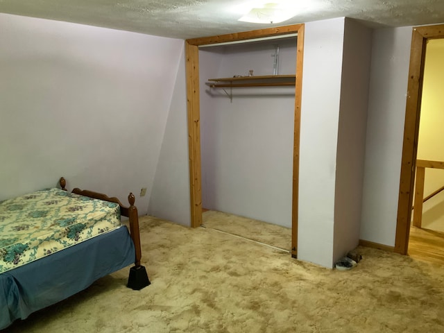 bedroom featuring a textured ceiling, carpet floors, and a closet