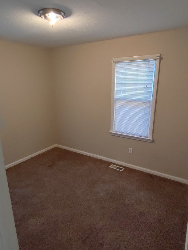 spare room with dark carpet