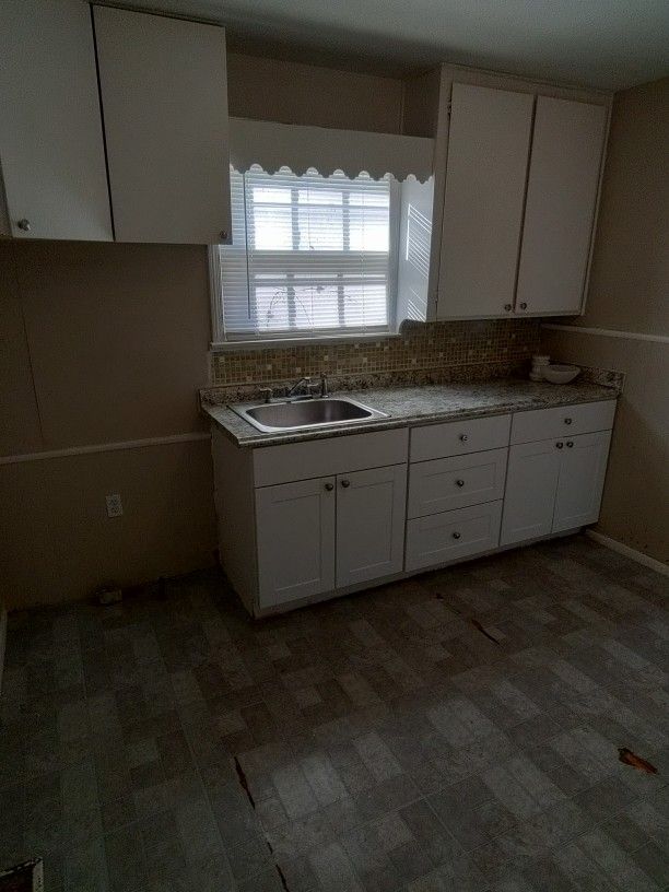 kitchen featuring white cabinets, tasteful backsplash, and sink