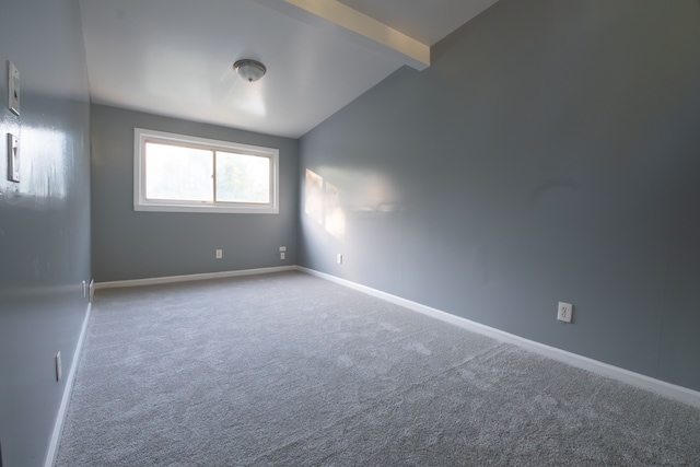 carpeted spare room with lofted ceiling with beams