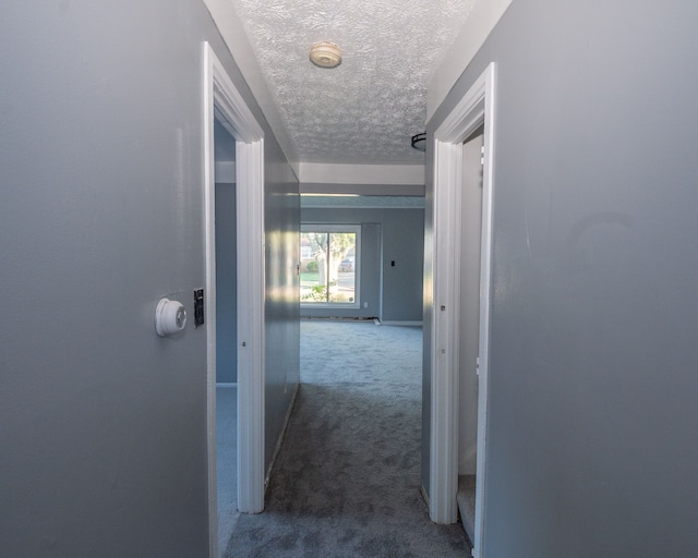 corridor featuring carpet floors and a textured ceiling