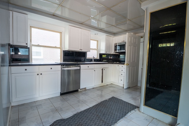 kitchen featuring white cabinets, sink, backsplash, and appliances with stainless steel finishes