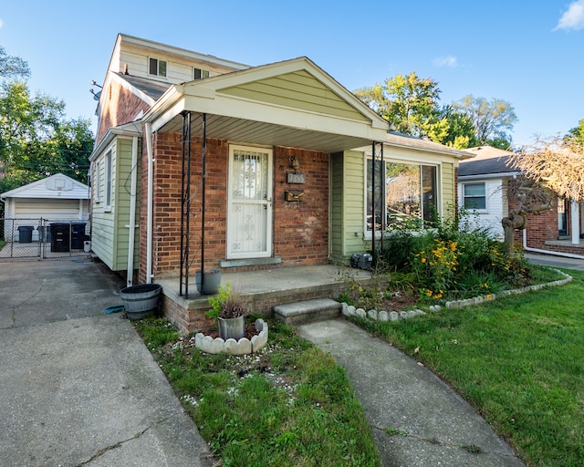 bungalow featuring covered porch, a garage, and an outdoor structure