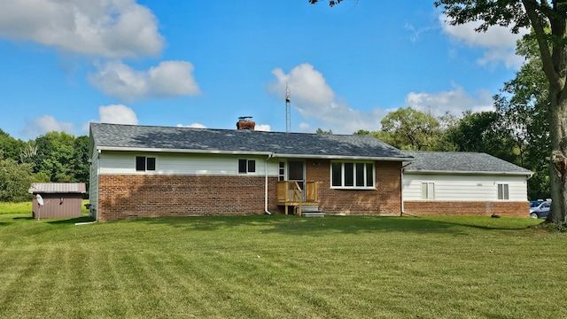 rear view of house with a yard and a storage unit