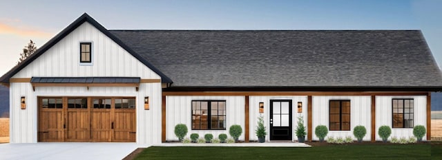 modern inspired farmhouse featuring a garage and a lawn