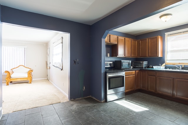 kitchen with dark colored carpet, electric stove, and sink