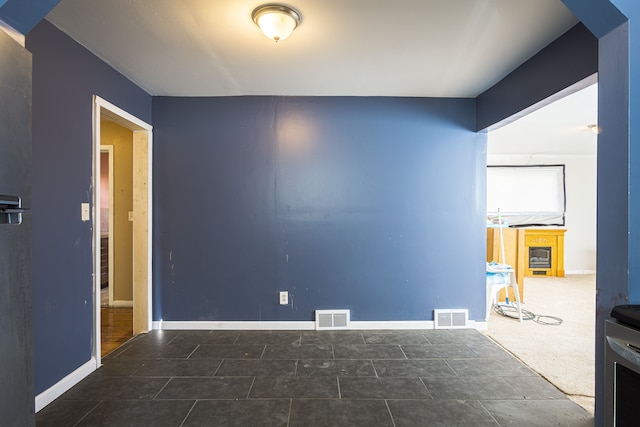 spare room with dark colored carpet