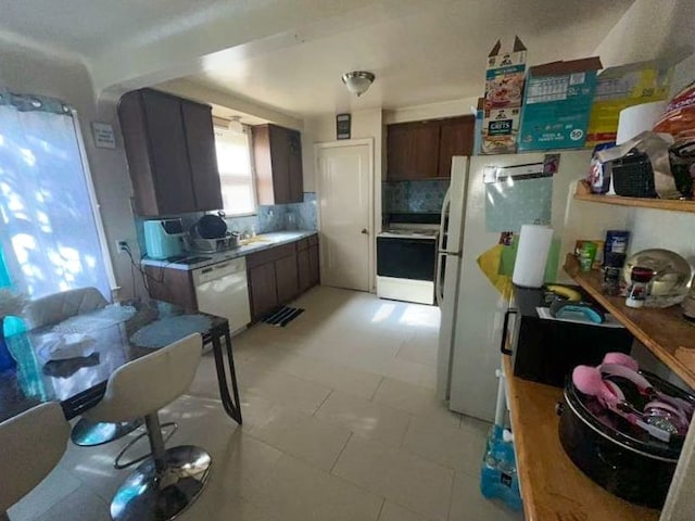 kitchen featuring decorative backsplash and white appliances