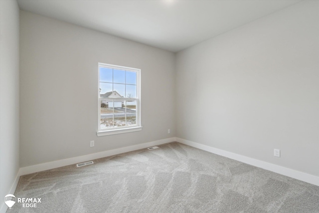 carpeted empty room with visible vents and baseboards