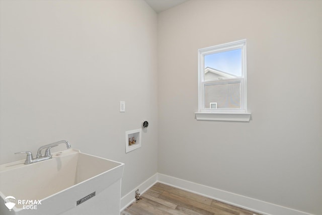 washroom with washer hookup, a sink, light wood-type flooring, laundry area, and baseboards