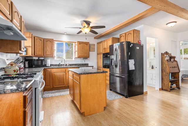 kitchen with stainless steel fridge, white range oven, a kitchen island, and a wealth of natural light