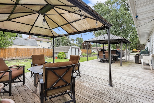 wooden deck with a gazebo and a storage shed