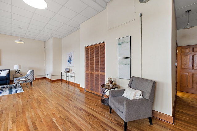 1395 Antietam Ave Unit 51, Detroit, MI 48207 - living area with a towering ceiling, light wood-style floors, baseboards, and a paneled ceiling