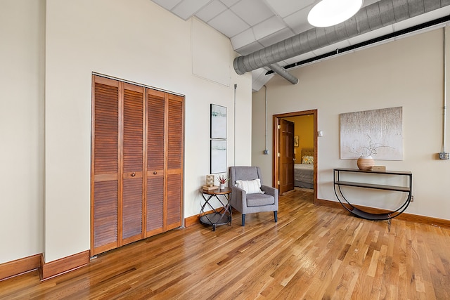 sitting room with a towering ceiling and light hardwood / wood-style flooring