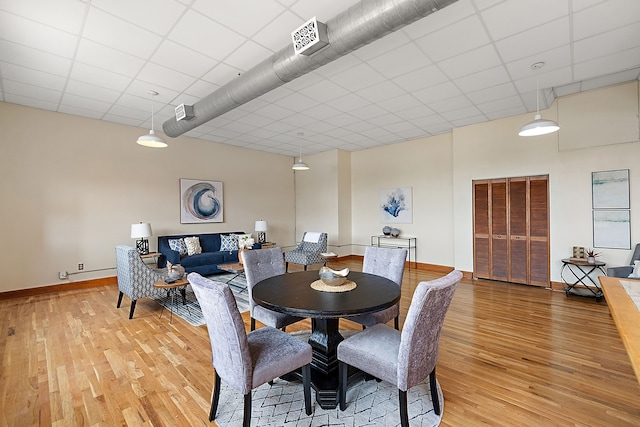 dining room featuring a drop ceiling and wood-type flooring