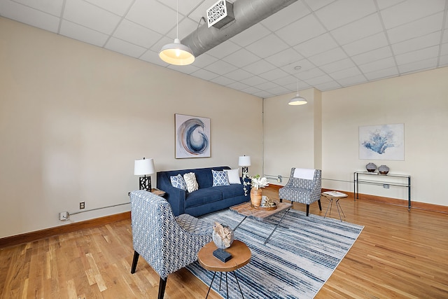 living room with hardwood / wood-style flooring and a drop ceiling