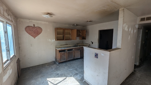14025 Dacosta St, Detroit, MI 48223 - kitchen featuring concrete floors, a peninsula, a sink, and brown cabinets