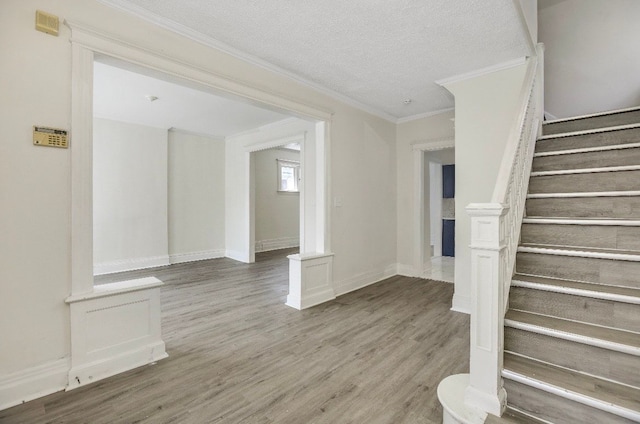 interior space featuring hardwood / wood-style floors, a textured ceiling, and crown molding