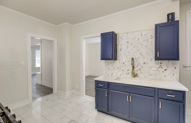 kitchen featuring light wood-type flooring, blue cabinets, ornamental molding, and sink