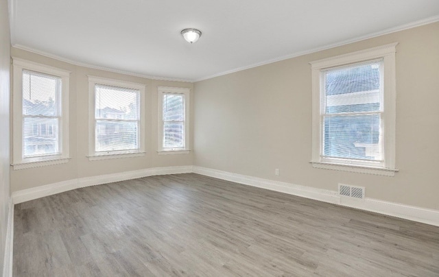 empty room featuring hardwood / wood-style floors and crown molding