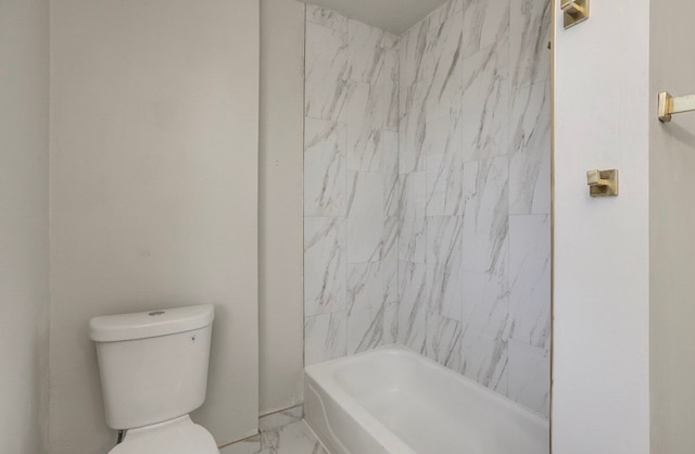 bathroom featuring tiled shower / bath combo and toilet