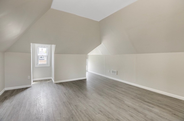 bonus room featuring vaulted ceiling and dark hardwood / wood-style floors