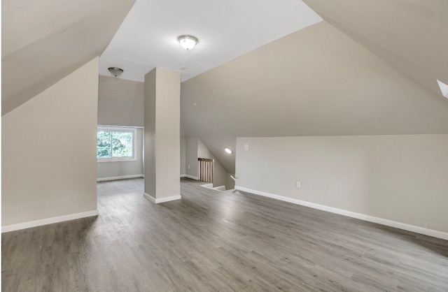 additional living space featuring lofted ceiling and hardwood / wood-style flooring