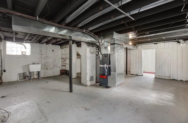 basement featuring heating unit and sink