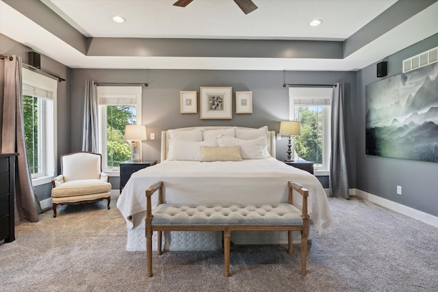 bedroom with multiple windows, ceiling fan, and carpet